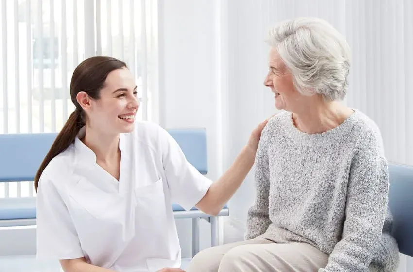Asistentă medicală care discută cu o pacientă înaintea examinării RMN